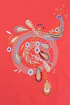 Embroidered bird on red cotton cloth