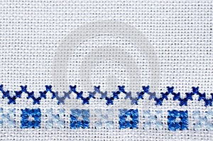 Embroidered fragment on white flax. Cross stitch.
