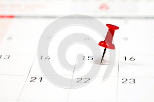 Embroidered red pins on a calendar on the 15th