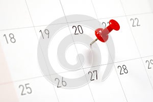 Embroidered red pins on a calendar on the 20th