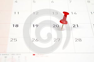 Embroidered red pins on a calendar on the 20th