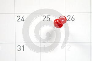 Embroidered red pins on a calendar on the 25th