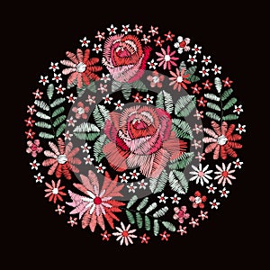 Embroidery. Beautiful round pattern with red roses and other flowers and leaves. Floral composition on black background