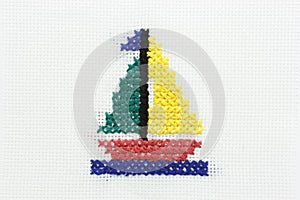 Embroidery of the image of a boat with a sail.