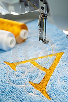 Embroidery machine and alphabet logo on towel