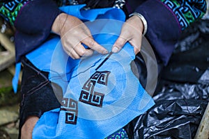 Embroidery with patterns on clothes close-up, woman`s hands embroidering a pattern on fabric