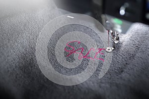 embroidery of pink lettering SALE on soft grey fabric with embroidery machine