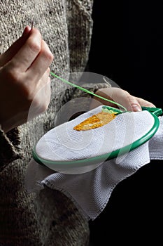 Embroidery in woman hands, female doing flower pattern embroidery on grandma natural clothes