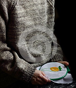 Embroidery in woman hands, female doing flower pattern embroidery on grandma natural clothes