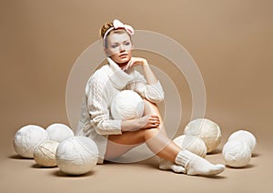 Embroidery. Woman sitting in White Cotton Knitwear with Heap Balls of Yarn