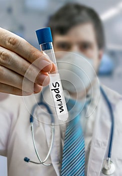 Embryologist doctor in sperm bank holds test tube with sperm sam photo