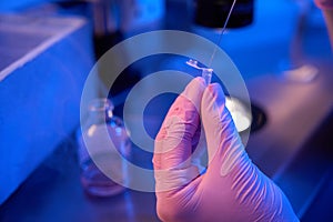 Embryologist in gloves transferring samples to cryotube, cryopreservation