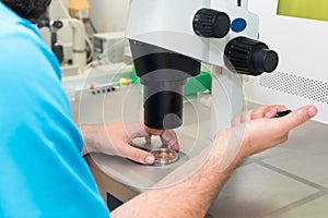 Embryologist or lab technician adjusting needle to fertilize a human egg under the microscope. Doctor adding sperm to egg using mi