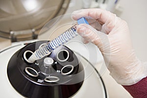 Embryologist putting sample into centrifuge photo