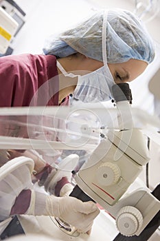 Embryologist using microscope