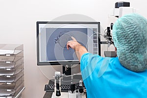 Embryologists perform test with human eggs. Doctor working on manipulator fertilizing human egg in fertility clinic lab,