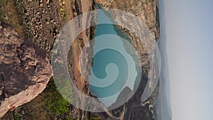 Emerald Azure lake in a flooded quarry in the shape of a heart. Oval lake in mining industrial crater, acid mine