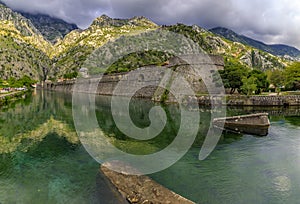 Emerald green waters of Kotor Bay or Boka Kotorska and the ancient wall of Kotor former Venetian fortress in Montenegro