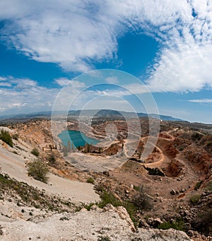 Emerald lake in a flooded quarry. Emerald green lake in flooded opencast mine, open pit. Oval lake in mining industrial crater,