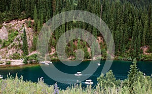 Emerald Lake Oasis Tranquil waters, lush hills, small boats, mountain backdrop photo