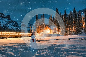 Emerald Lake with wooden cottage and snowman in falling snow at Yoho national park, Canada