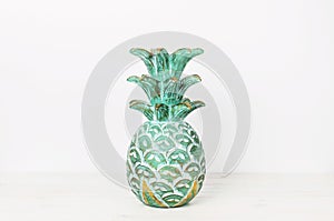 Emerald wooden tropical pineapple on a white wall background. Modern home decor mock-up, accessories in the house. Interior backgr