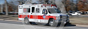 Emergency ambulance speeding with dynamic motion blur effect on urban road at night