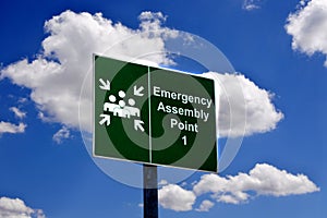 Emergency assembly point sign against blue sky