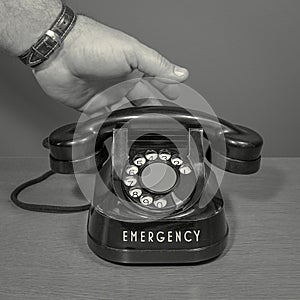 Emergency. black and white. Hand picks up the phone. old telephone set. square format