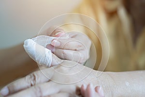 Emergency concept. Doctor applying bandage onto finger of old woman