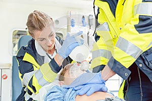 Emergency doctor giving cardiac massage for reanimation in ambulance