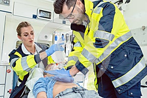 Emergency doctor giving cardiac massage for reanimation in ambulance