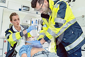 Emergency doctor giving cardiac massage for reanimation in ambulance photo