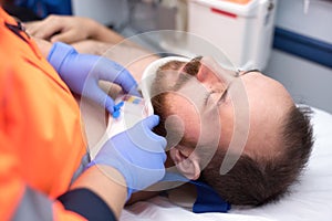 Emergency doctor putting a cervical collar to a patient in the ambulance