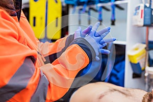 Emergency doctor putting on gloves in ambulance