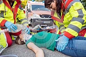 Emergency doctor ventilating injured woman after motorbike accident