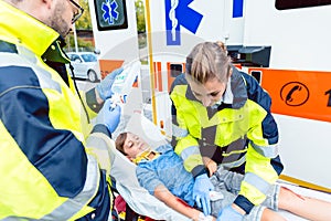 Emergency doctors putting injured boy in ambulance