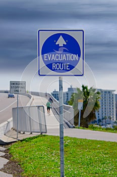 Emergency Evacuation Route sign and running people