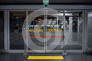 Emergency Exit door in airport terminal, with access to restricteed area. Hospital doors with quarantine warning