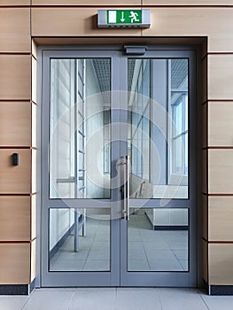 Emergency exit with glass door in airport office building. Entrance by passes.