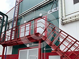 Emergency exit with metal stairs on the facade of an industrial building, store, warehouse, logistics center. Iron staircase for