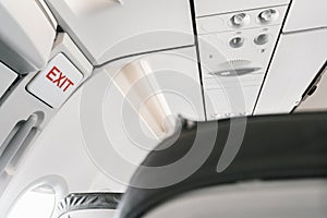 Emergency exit sign on airplane. Empty airplane seats in the cabin. Modern Transportation concept. Aircraft long