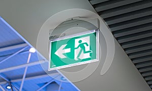 Emergency exit sign in an airport. Public safety, evacuation concept