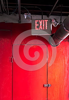 Emergency exit sign over a red door