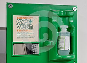 Emergency eye wash station safety kit with directions attached to a wall.