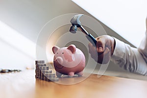 Emergency finance, Businessman using a hammer is about to destroy the pink piggy bank