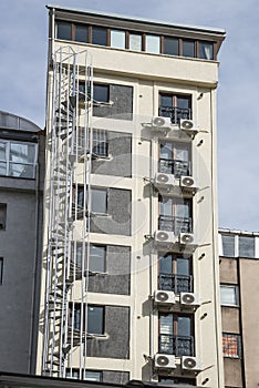 Emergency metal staircase at the back of the building with airconditioners.