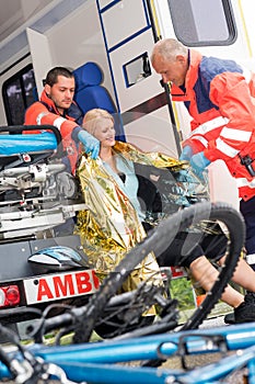 Emergency paramedics helping woman bike accident photo