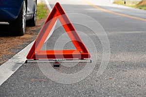 Emergency red warning triangle on the road sign with white traffic line