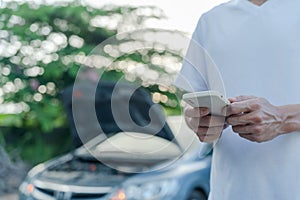 emergency safety. man is dialing a cell phone for an emergency number due to a car breakdown in the forest. Maintenance of the car